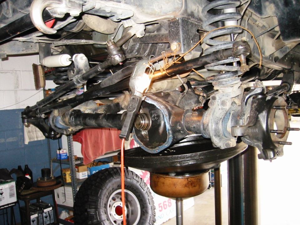 Underside of Ford Bronco front axle with diff cover removed on a shop lift