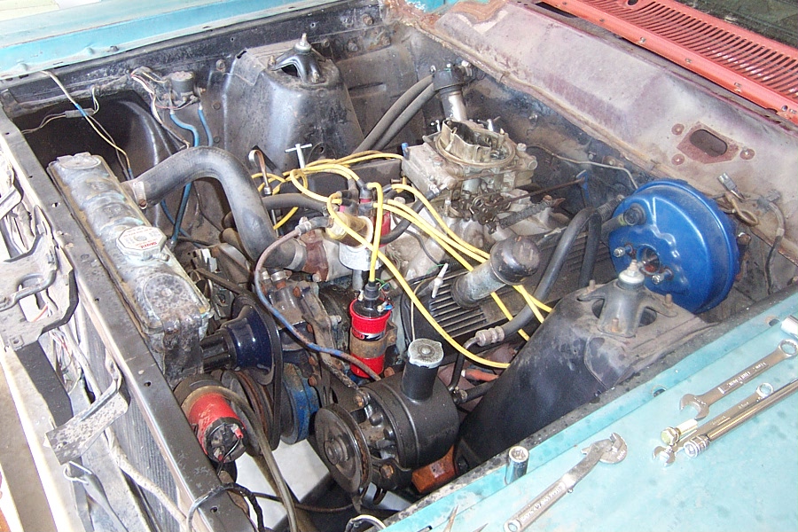 1966 Ford Fairlane engine bay with V8 engine, carburetor, and yellow spark plug wires