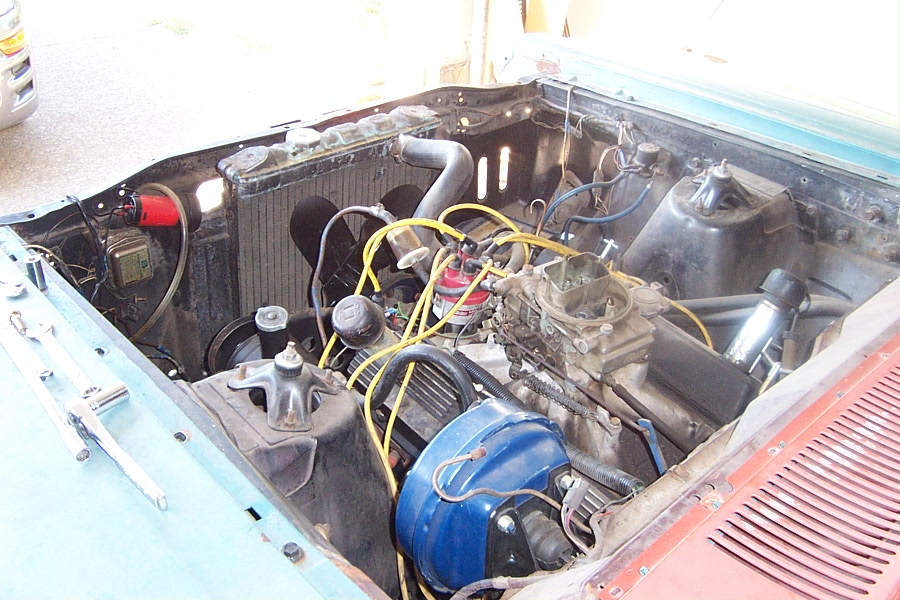 1966 Ford Fairlane engine bay with V8 engine, carburetor, and yellow spark plug wires