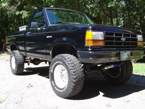 1989 Ford Ranger - A black 1989 Ford Ranger pickup truck is shown with a lifted suspension and large off-road tires.