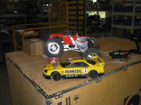 1994 Ford Bronco - Two remote control vehicles, a yellow sports car and a red monster truck, are displayed on a large wooden crate.
