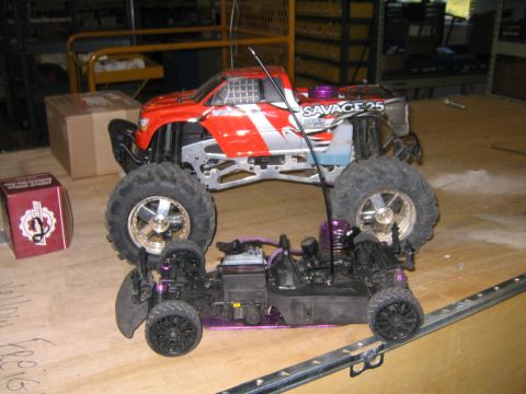 1994 Ford Bronco - Two remote control vehicles, a monster truck and a car chassis, are displayed on a wooden surface.