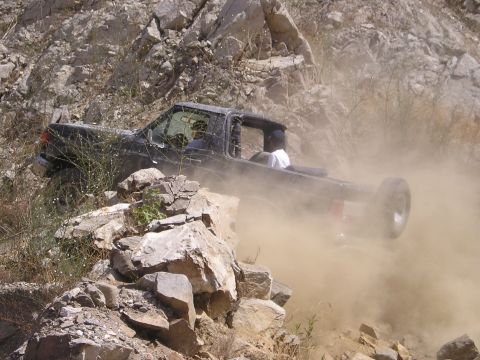 1989 Ford Bronco - This off-road vehicle navigates a challenging, dusty, and rocky path.