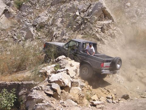 1989 Ford Bronco - This 1989 Ford Bronco is tackling a challenging off-road course on a dusty, rocky hillside.