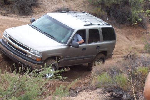 1992 Ford Bronco - Chevrolet Tahoe navigating a rough, unpaved trail in a dry, brushy environment.