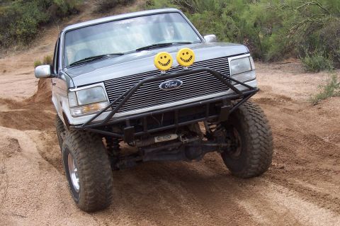 1992 Ford Bronco - This 1992 Ford Bronco navigates a dusty, off-road path with its front end angled towards the camera.