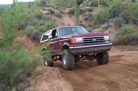 1992 Ford Bronco - This 1992 Ford Bronco is navigating a challenging off-road course in a desert environment.