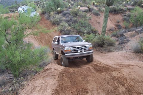 1992 Ford Bronco - A 1992 Ford Bronco navigates a desert trail, with another vehicle in the distance.