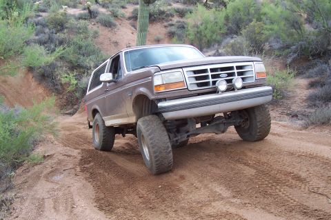 1992 Ford Bronco - This 1992 Ford Bronco navigates a dusty trail in a desert landscape.