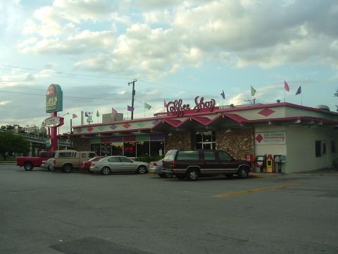 1993 Ford Taurus - A coffee shop with a prominent "Pie Stand" sign and several vehicles parked outside on a cloudy day.