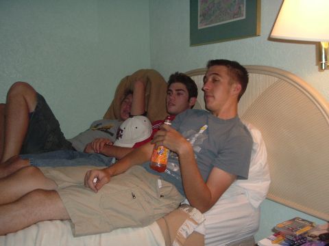 1993 Ford Taurus - Three young men relax on a bed, with a bottle of orange soda visible.