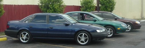 Blue 1993 Ford Taurus sedan parked in a row with other cars