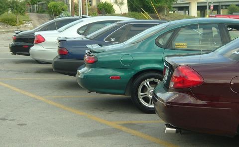 1993 Ford Taurus - A line of sedans, including a green 1993 Ford Taurus, are parked in a lot.