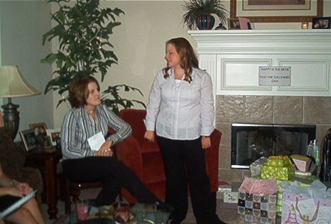 1985 Ford LTD Crown Victoria - A gathering in a living room features two women conversing near a fireplace adorned with gifts and decorative items.