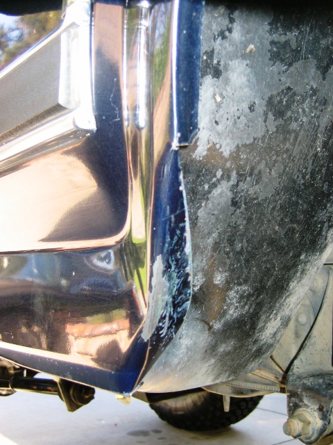 1985 Ford Bronco - This close-up shot focuses on the lower body panel and wheel well of a vehicle, revealing signs of wear and tear.