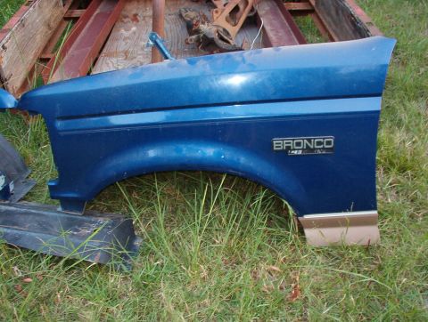 1996 Ford Bronco - A blue Ford Bronco fender is shown, with a badge indicating it's a 5.0L model.