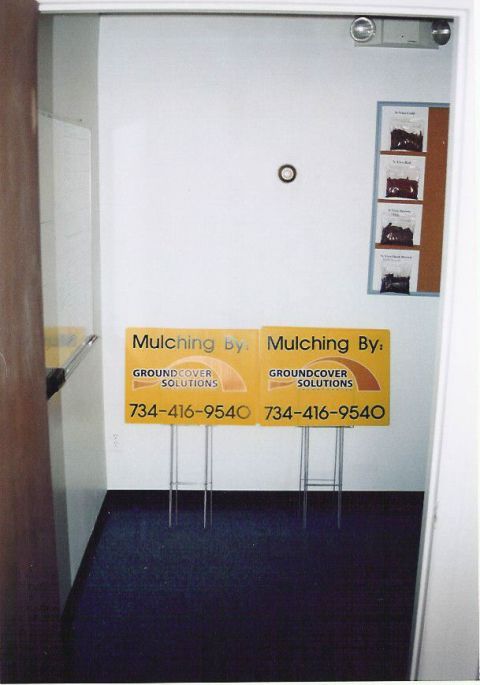 1999 Jeep Grand Cherokee - Yard signs advertising mulching services are displayed indoors near a bulletin board.