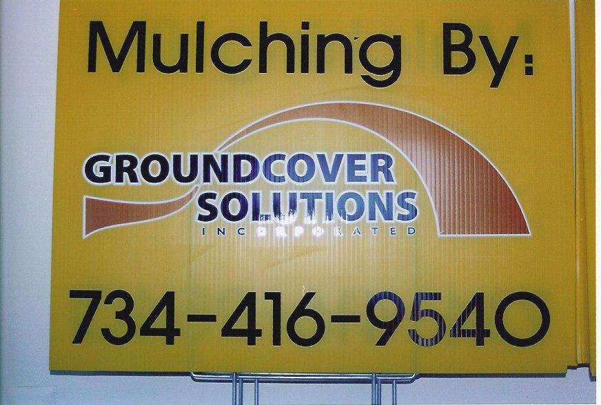 Yellow sign with "Mulching By: GROUNDCOVER SOLUTIONS INCORPORATED 734-416-9540"