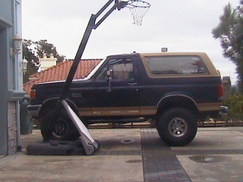 1991 Ford Bronco - A Ford Bronco is parked on a driveway next to a basketball hoop.