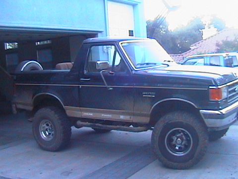 1991 Ford Bronco - This Ford Bronco is parked inside a garage with the rear door open, showing a spare tire.