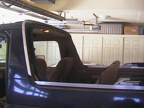 1991 Ford Bronco - Interior view of a 1991 Ford Bronco with brown upholstery and the soft top removed.