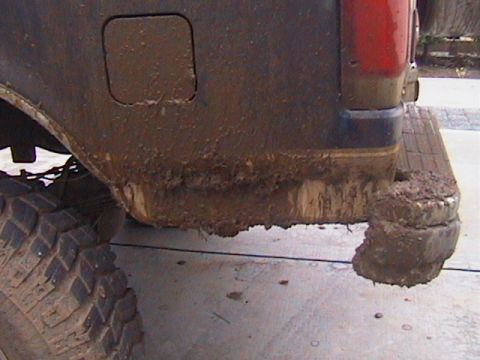 1991 Ford Bronco - This vehicle's rear end is heavily coated in mud, obscuring most details.