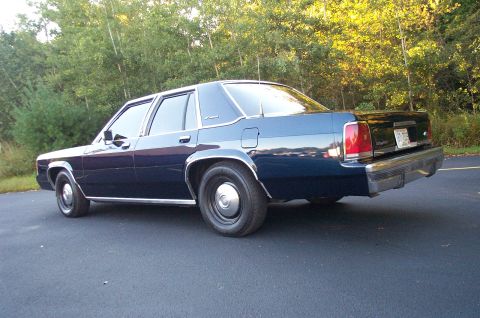 1991 Ford LTD Crown Victoria - Rear 3/4 view of a dark blue 1991 Ford Crown Victoria LTD sedan parked on asphalt.