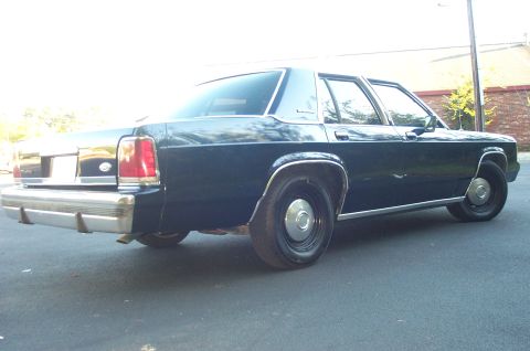 1991 Ford LTD Crown Victoria - This 1991 Ford Crown Victoria LTD is viewed from the rear, showing its dark blue paint and chrome bumper.