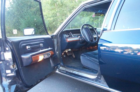 1991 Ford LTD Crown Victoria - The interior of a 1991 Ford Crown Victoria LTD, plush blue upholstery and wood trim accents.