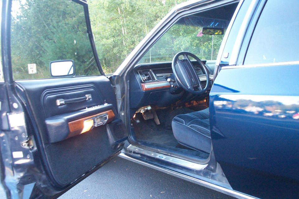 Interior of a 1991 Ford Crown Victoria LTD showing the driver's seat, dashboard, and door panel