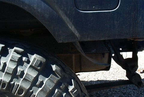 1986 Ford Bronco - Close-up view of a vehicle's rear fender and a large off-road tire a unique deer tread pattern.