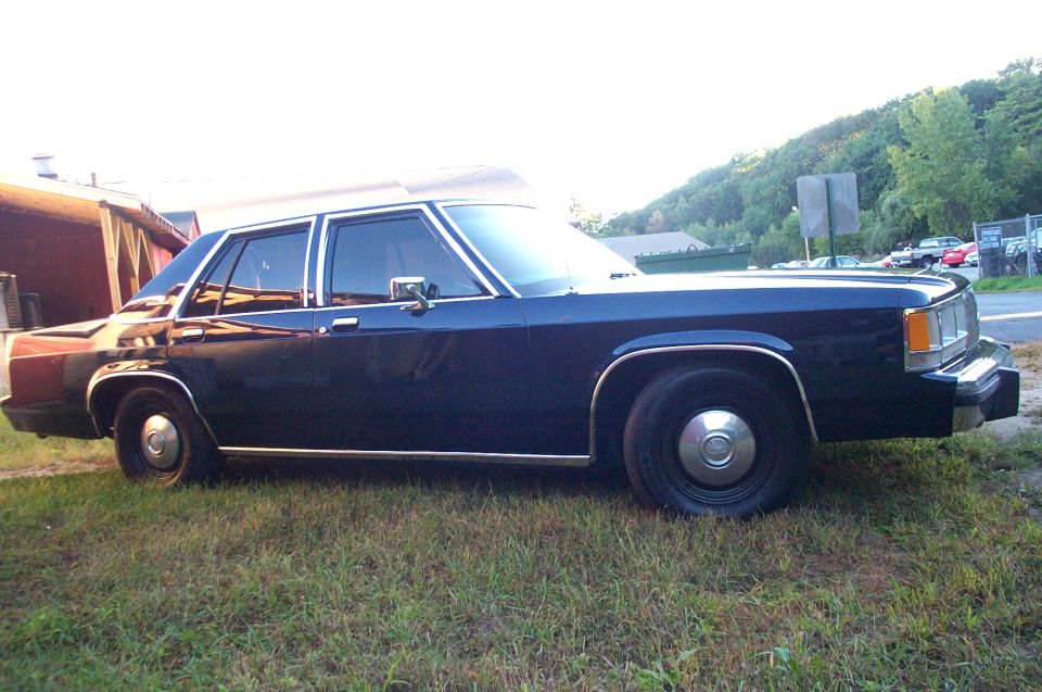 Dark blue 1991 Ford Crown Victoria parked on grass, side view
