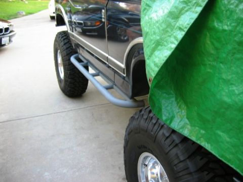 1985 Ford Bronco - Side view of a 1985 Ford Bronco showing its rock sliders and lifted suspension.