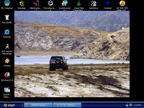 1985 Ford Bronco - 1985 Ford Bronco seen off-road near a body of water with hills behind it.
