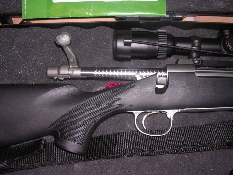 1985 Ford Bronco - Close-up view of a bolt-action rifle, including its scope and textured grip, resting in a case.