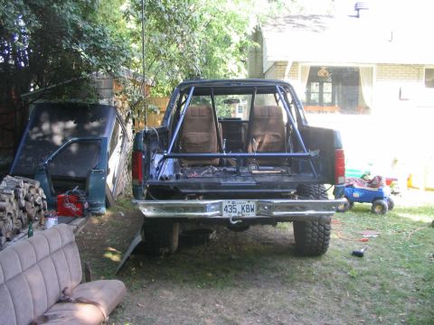 1986 Ford Bronco - Rear view of a 1986 Ford Bronco with a custom roll cage and the hardtop removed.