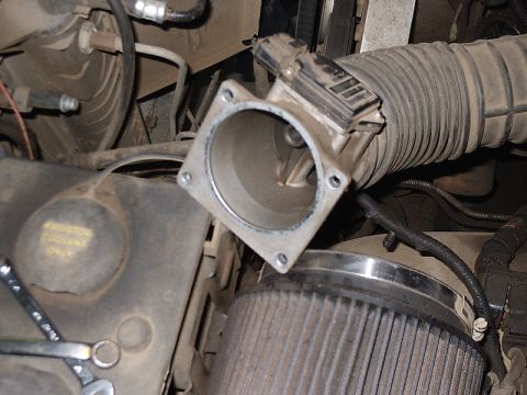 1996 Ford Bronco - Close-up of a vehicle's engine bay showing a removed throttle body and air intake components.