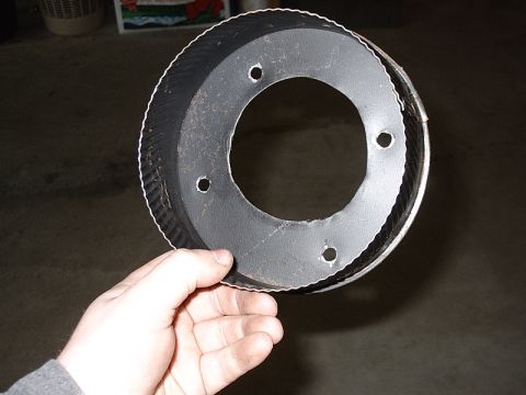 1996 Ford Bronco - Circular metal part with bolt holes and corrugated edge being held by a hand.