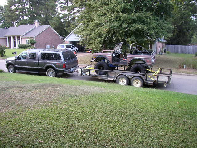Ford Bronco on a trailer being towed by an SUV