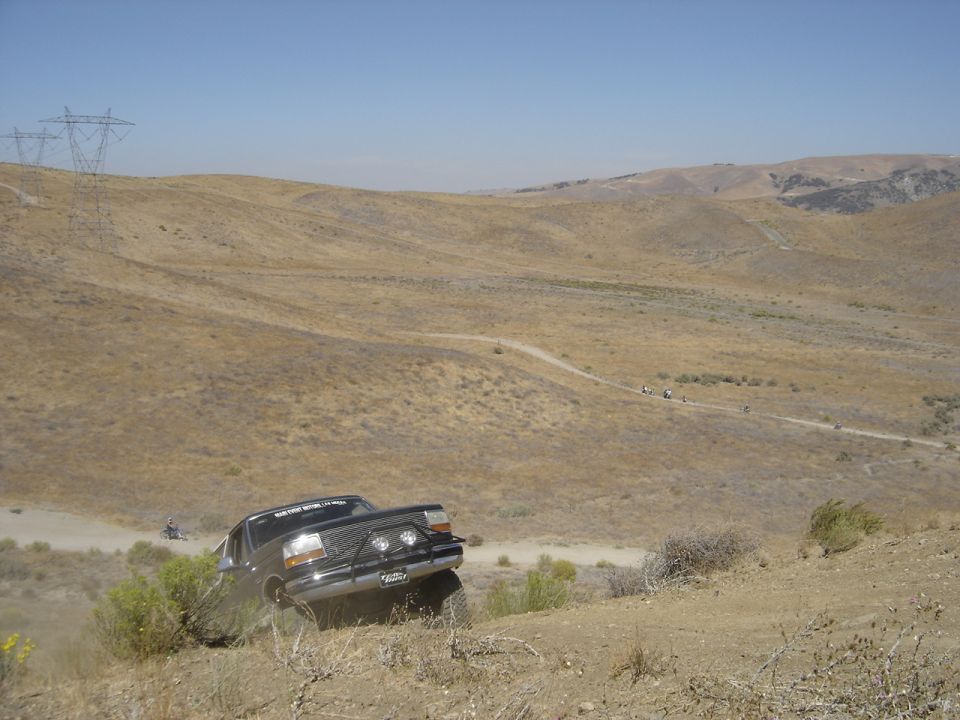 Black 1995 Ford F-Series truck driving off-road