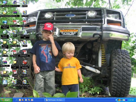 1986 Ford Bronco - A lifted Ford truck with a warning sticker on the grille is shown with two young children standing in front of it.