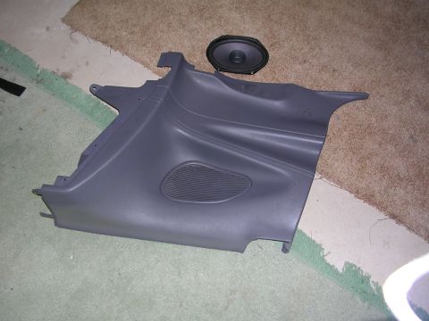 2003 Chevrolet Monte Carlo - Car door panel and speaker removed from a vehicle, lying on carpeted floor.
