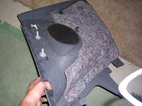 2003 Chevrolet Monte Carlo - A person holds a disassembled car door panel, revealing the speaker and insulation material.