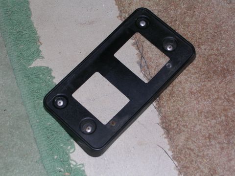 2003 Chevrolet Monte Carlo - This black plastic license plate bracket features two rectangular openings and four visible mounting points.