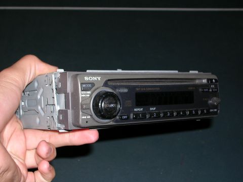 2003 Chevrolet Monte Carlo - A Sony car stereo is held in a hand, showing its front panel with buttons and a display screen.