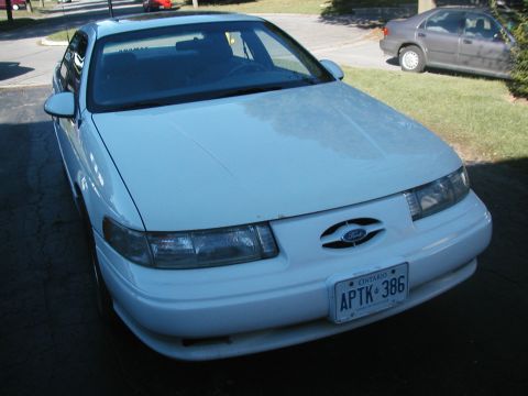 1993 Ford Taurus - A white 1993 Ford Taurus is seen from the front, displaying its license plate.