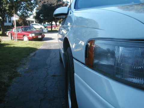 1993 Ford Taurus - Side view of a white 1993 Ford Taurus, with another car visible in the background.
