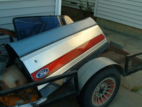1990 Ford Bronco - A Ford tailgate with a red stripe and Ford logo is loaded onto a trailer.