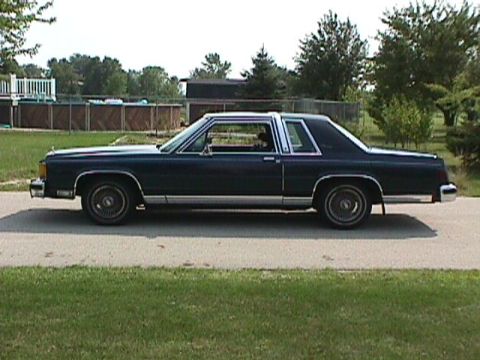1985 Ford LTD Crown Victoria - Driver-side profile of a dark green two-door Ford full-size coupe with a formal roofline, opera-style rear quarter window and chrome bodysi…