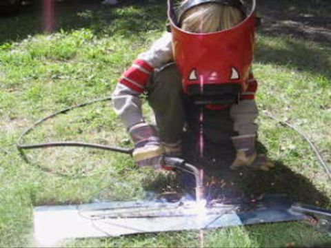 1986 Ford Bronco - Child is welding metal outdoors while wearing a welding mask and protective gear.